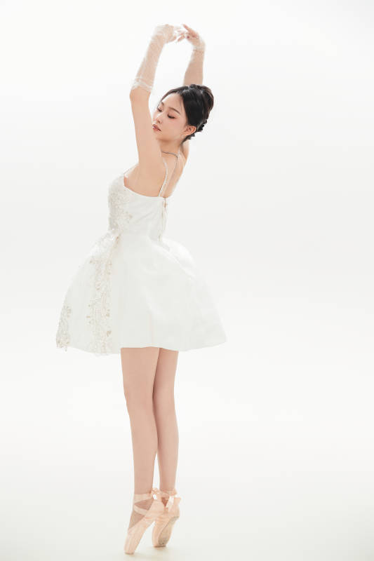 白色背景下跳芭蕾舞的亚洲少女