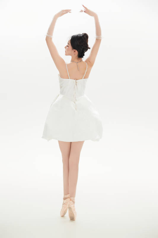 白色背景下跳芭蕾舞的亞洲少女