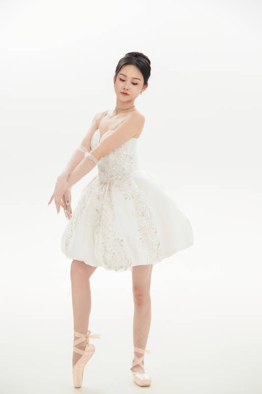 白色背景下跳芭蕾舞的亚洲少女