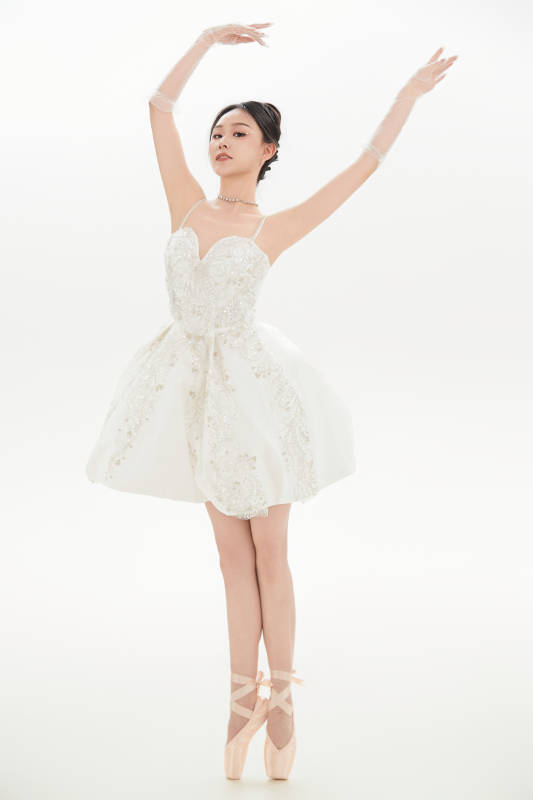 白色背景下跳芭蕾舞的亚洲少女