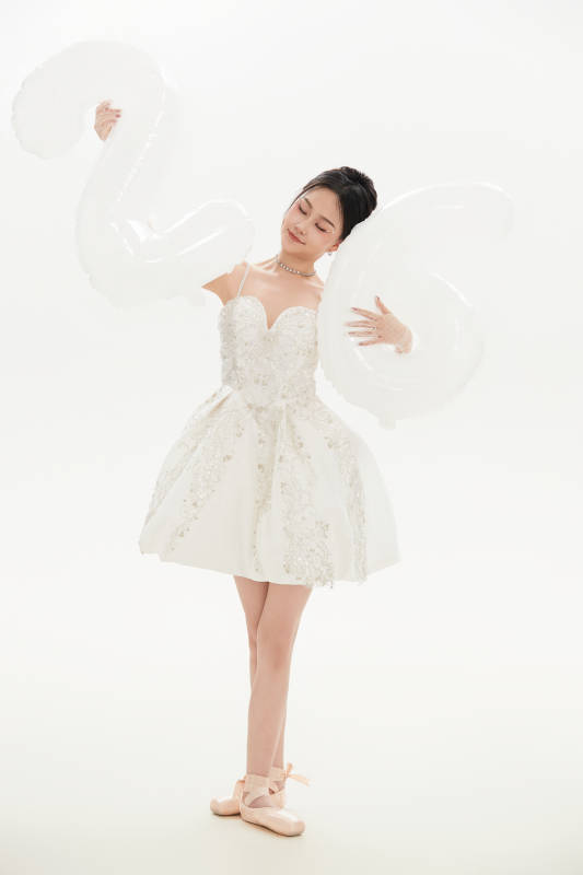 白色背景下跳芭蕾舞的亚洲少女