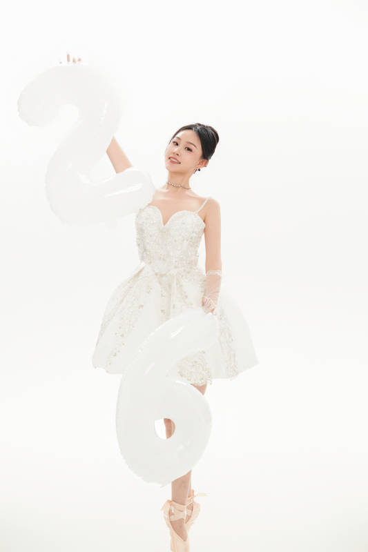 白色背景下跳芭蕾舞的亚洲少女