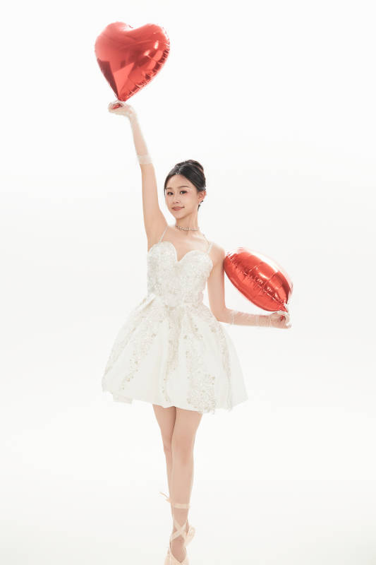 白色背景下跳芭蕾舞的亚洲少女