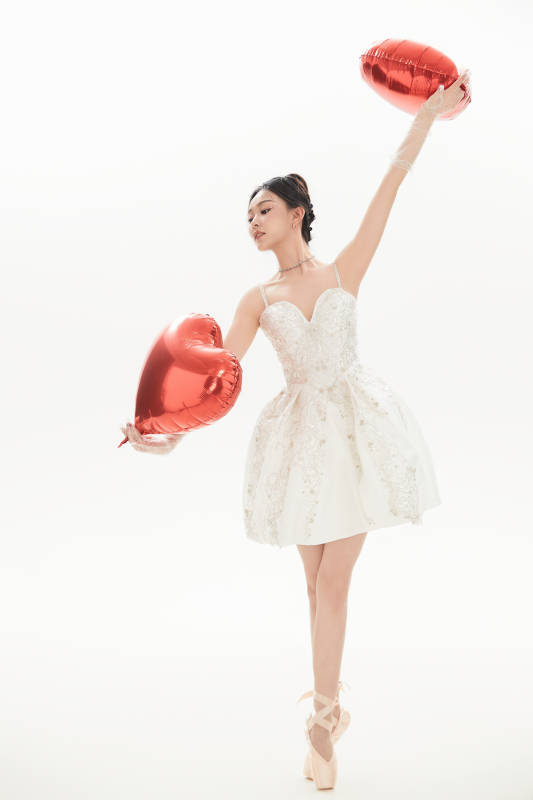 白色背景下跳芭蕾舞的亚洲少女