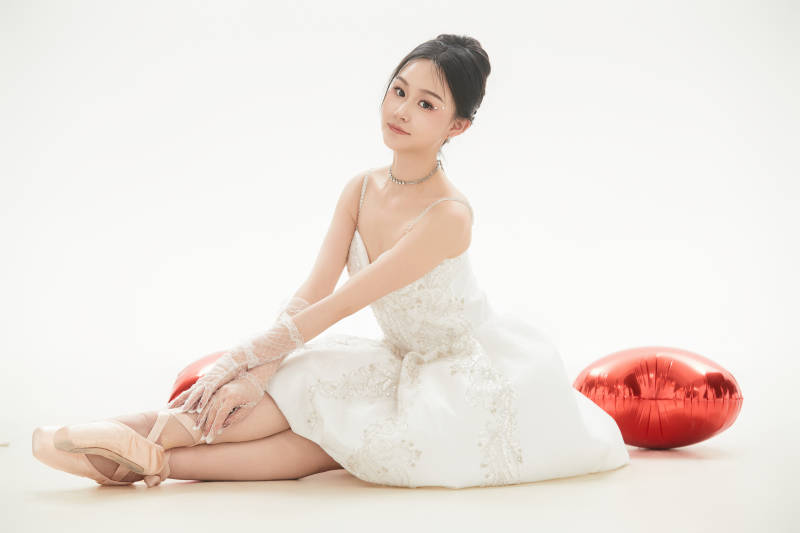 白色背景下跳芭蕾舞的亚洲少女