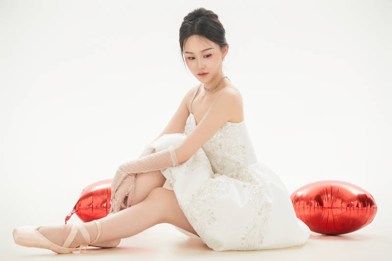 白色背景下跳芭蕾舞的亚洲少女