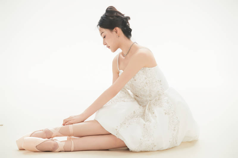 白色背景下跳芭蕾舞的亚洲少女