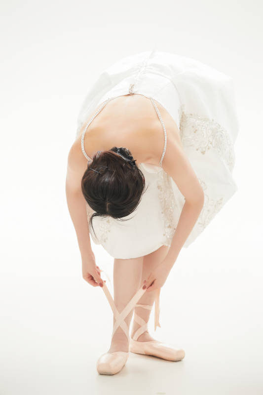 白色背景下跳芭蕾舞的亚洲少女