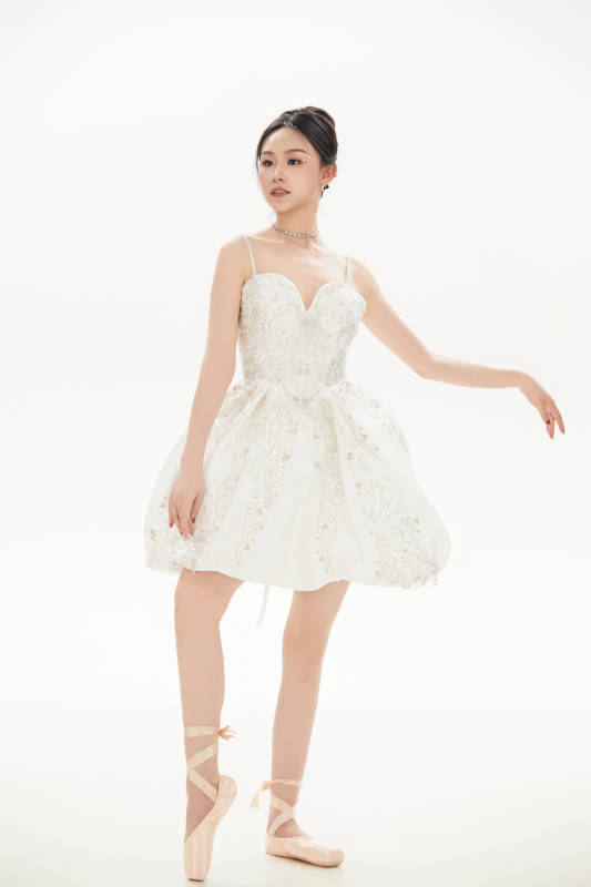 白色背景下跳芭蕾舞的亚洲少女