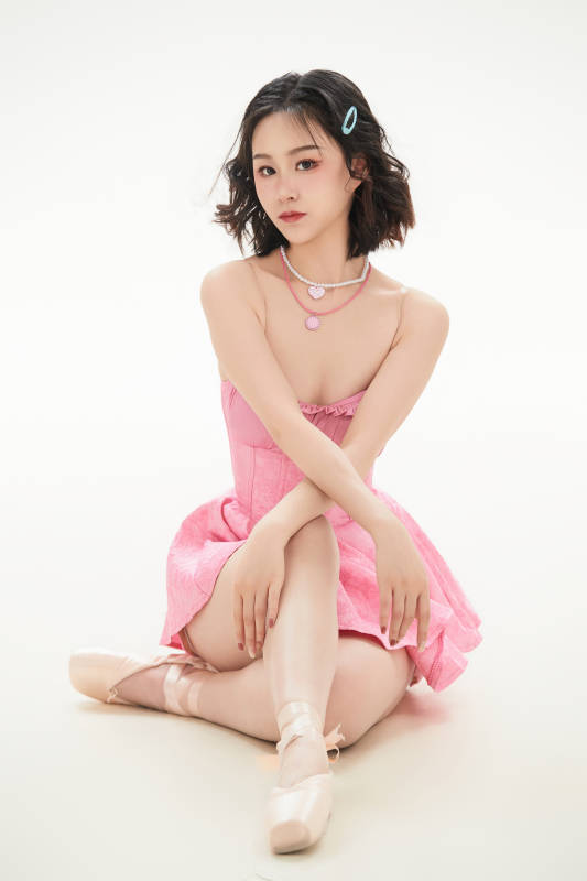 身穿粉色芭蕾舞服跳舞的亚洲少女