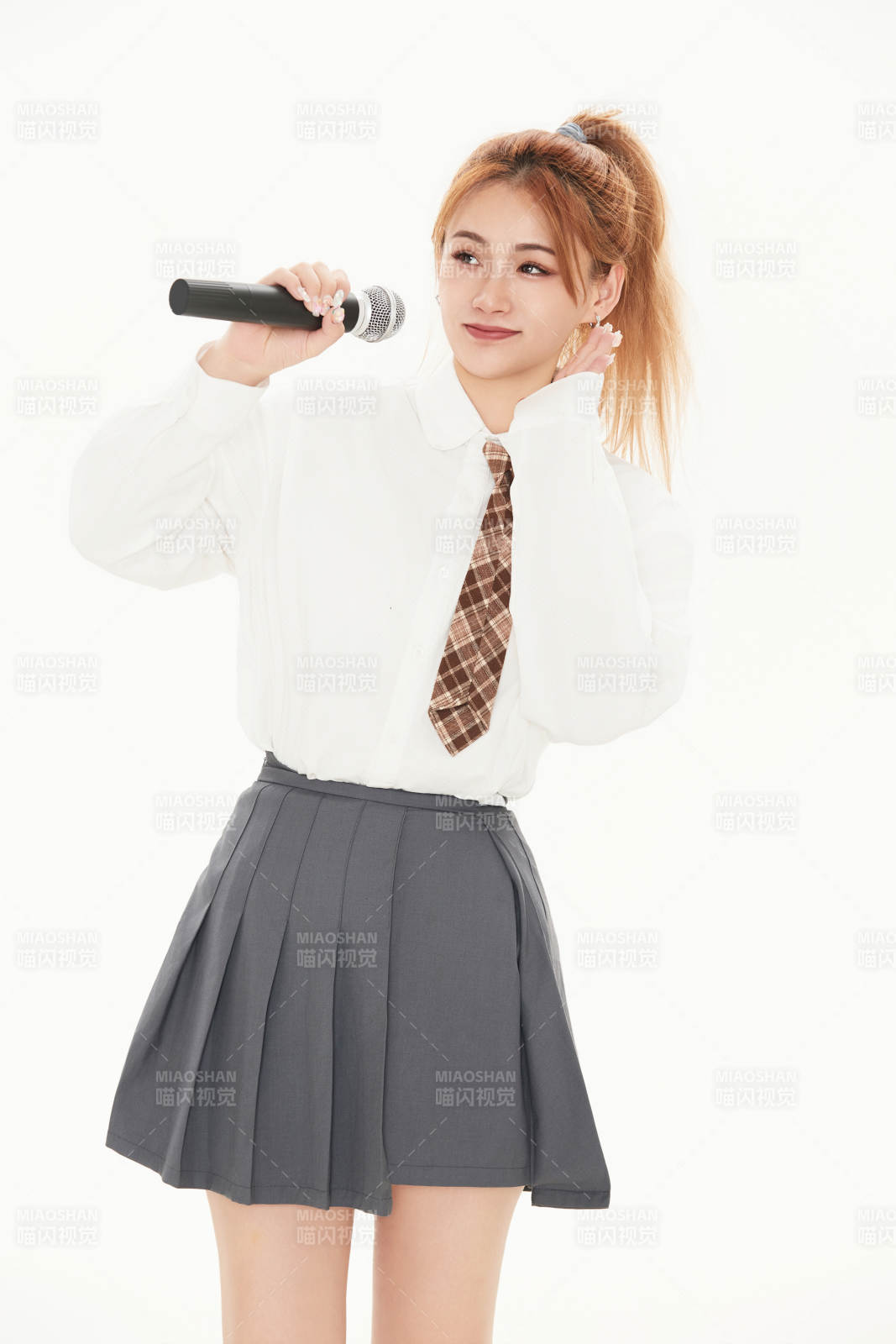 白色背景下站在麥克風前唱歌的亞洲女性