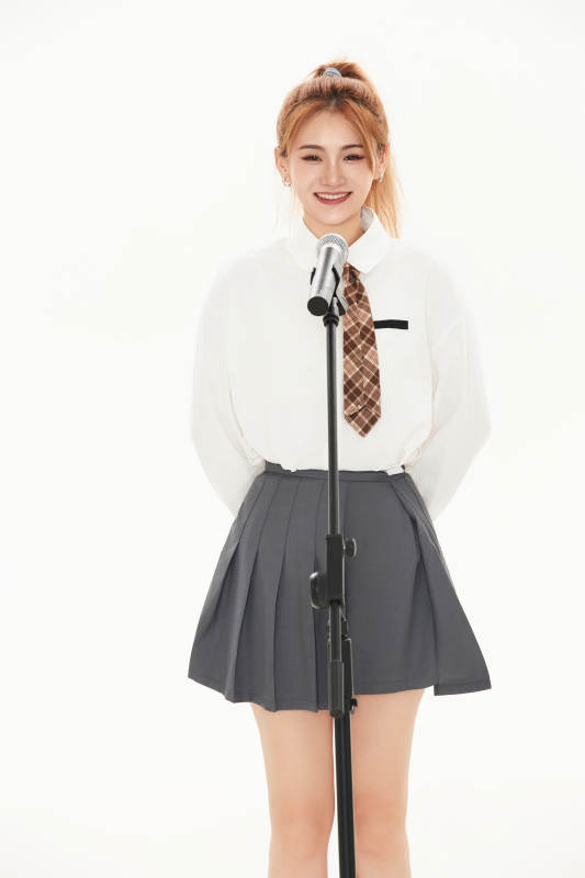 白色背景下站在麦克风前唱歌的亚洲女性