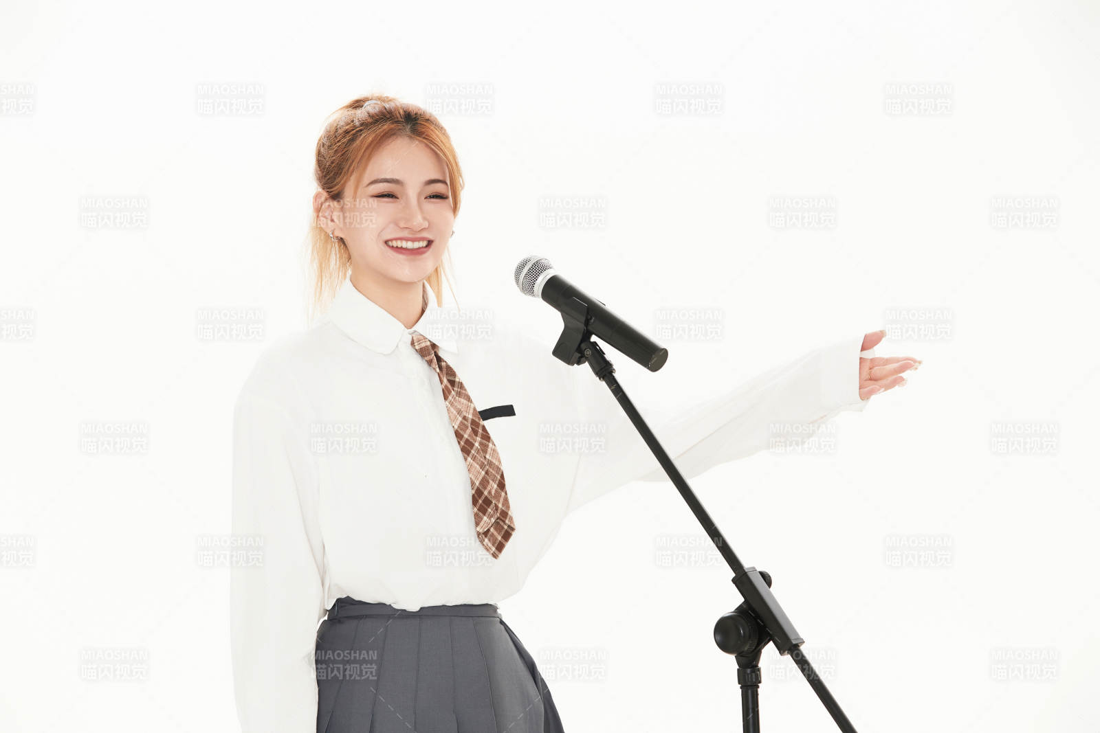 白色背景下站在麦克风前唱歌的亚洲女性