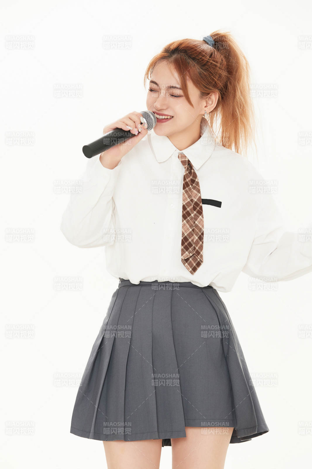 白色背景下站在麦克风前唱歌的亚洲女性