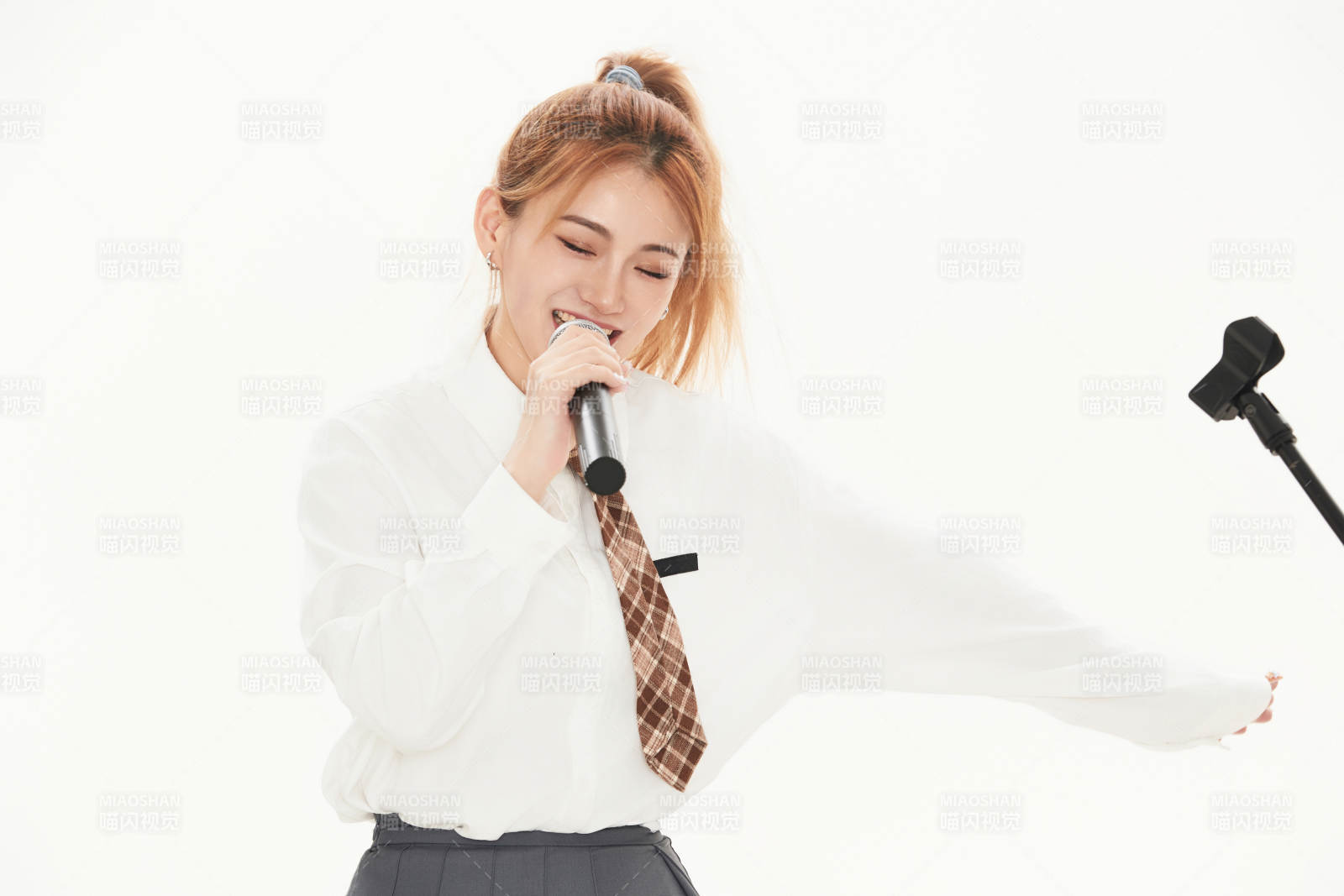 白色背景下站在麦克风前唱歌的亚洲女性