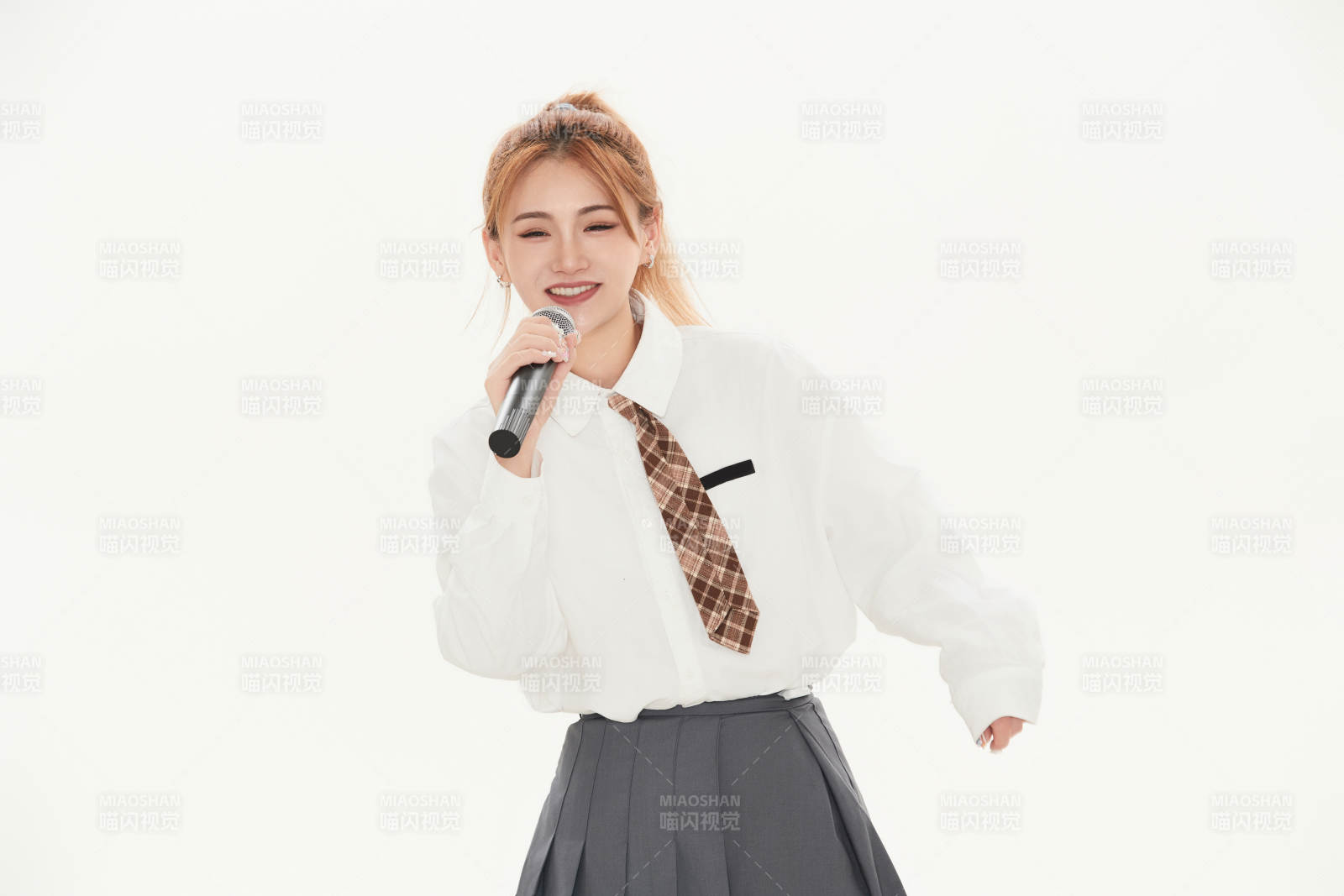 白色背景下站在麦克风前唱歌的亚洲女性