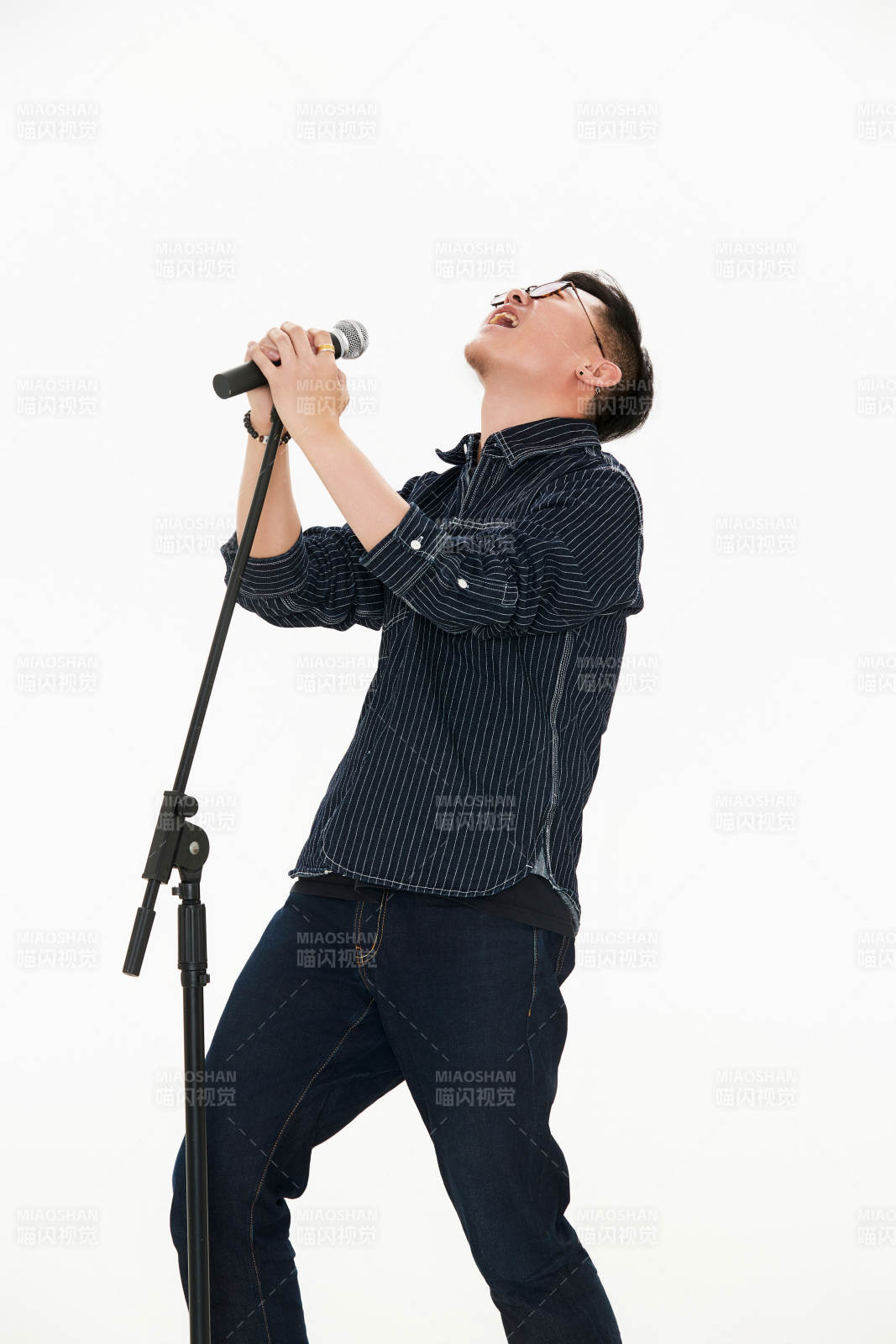 白色背景下站在麦克风前唱歌的亚洲男性