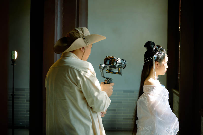 穿着汉服在古城拍照的东方美女