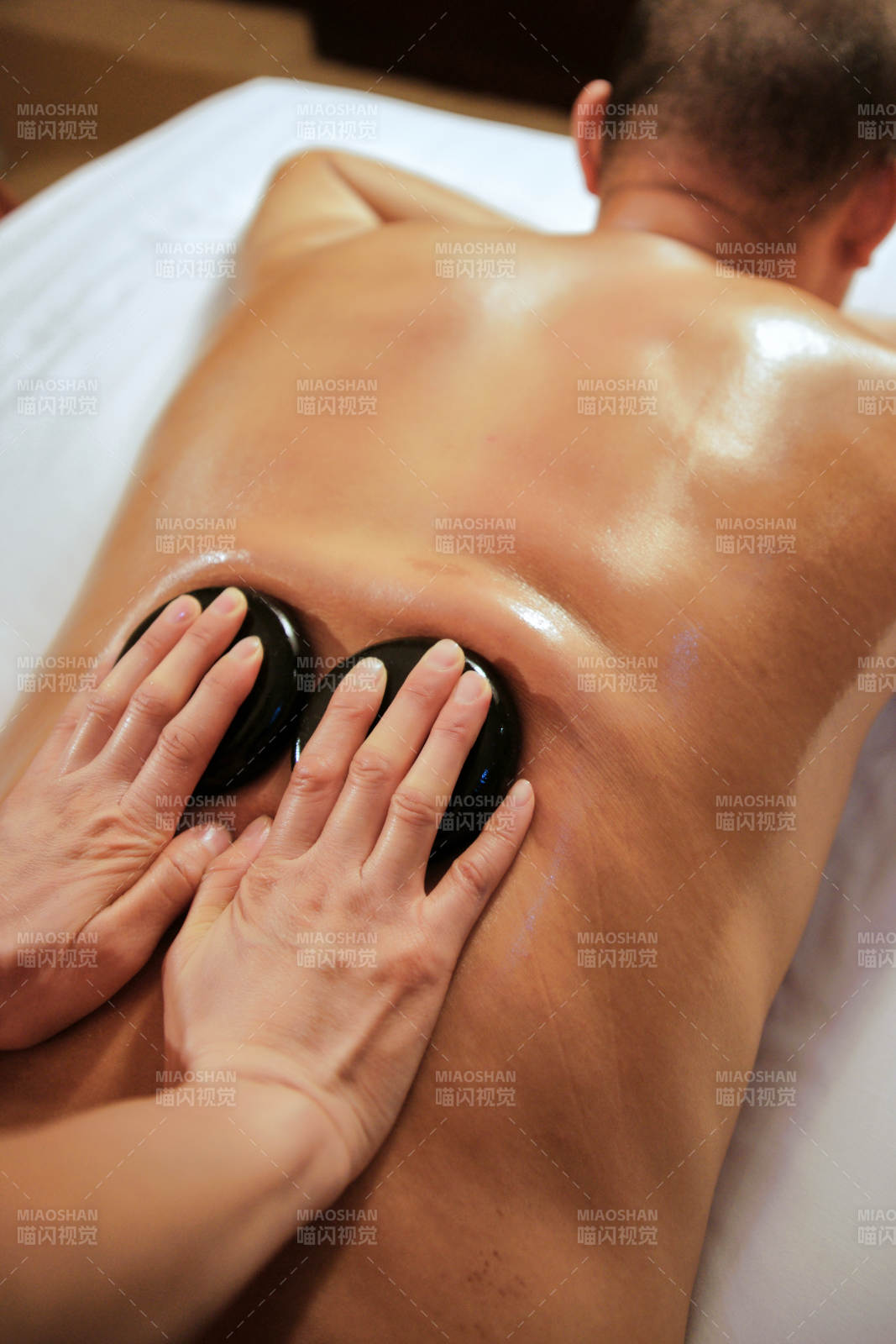 专业的按摩技师为顾客进行玉石推拿