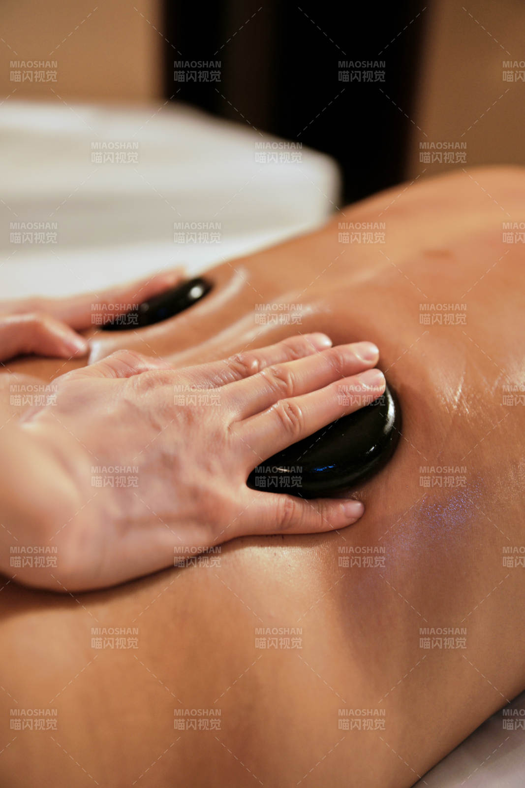 专业的按摩技师为顾客进行玉石推拿