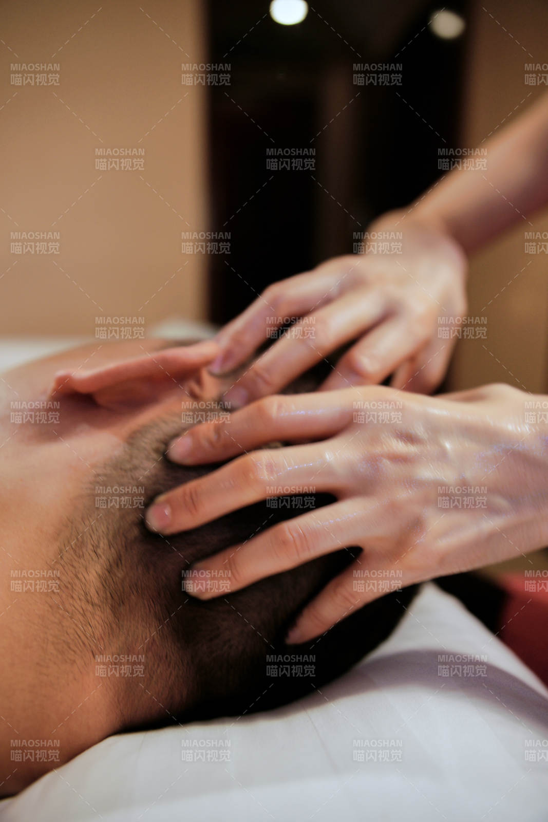 专业的按摩技师为顾客进行头部保健按摩