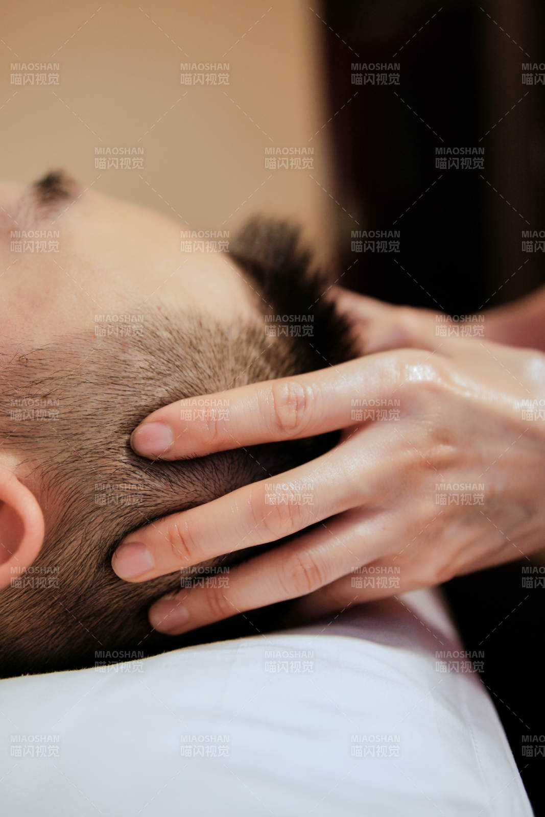 专业的按摩技师为顾客进行头部保健按摩