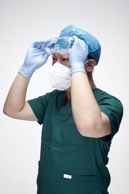 穿刷手衣黛手术帽手术手套护目镜的男性医生