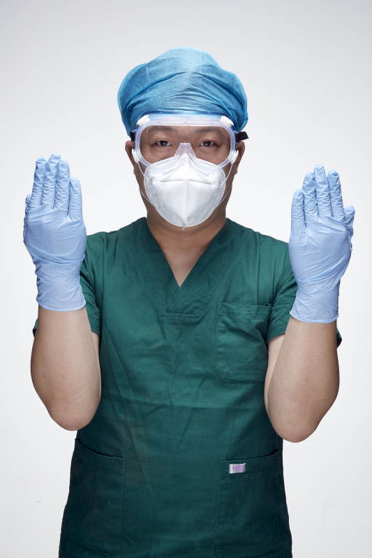 穿刷手衣黛手术帽手术手套护目镜的男性医生