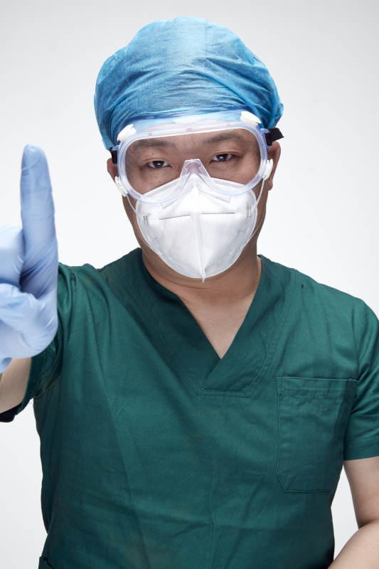 穿刷手衣黛手術帽手術手套護目鏡的男性醫生