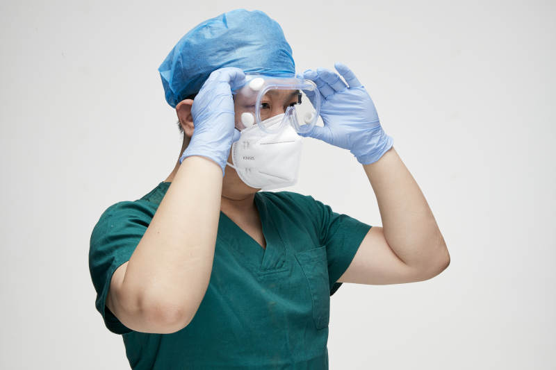穿刷手衣黛手术帽手术手套护目镜的男性医生