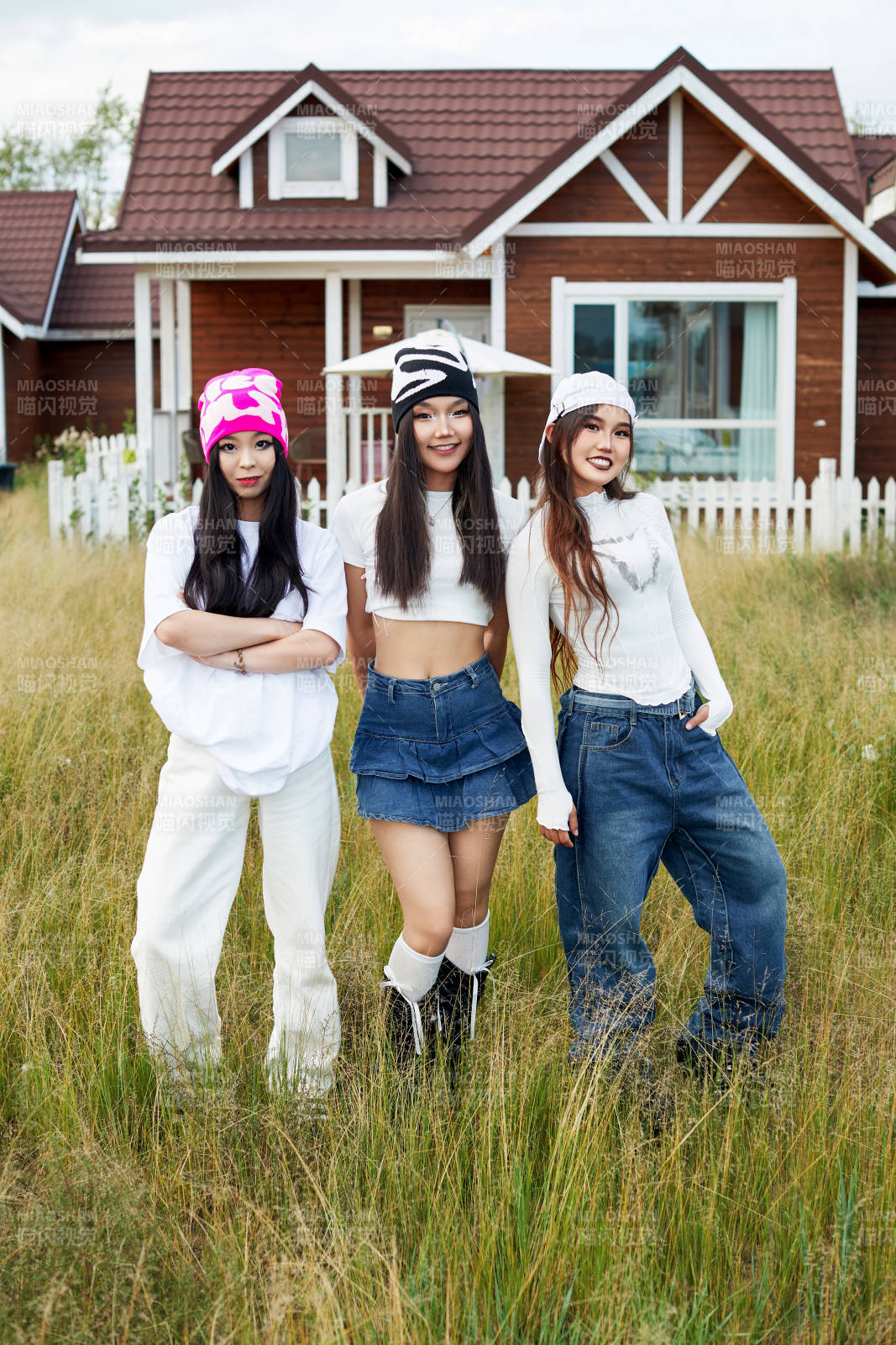 在旅游景区民宿外游玩拍照的三个姑娘们