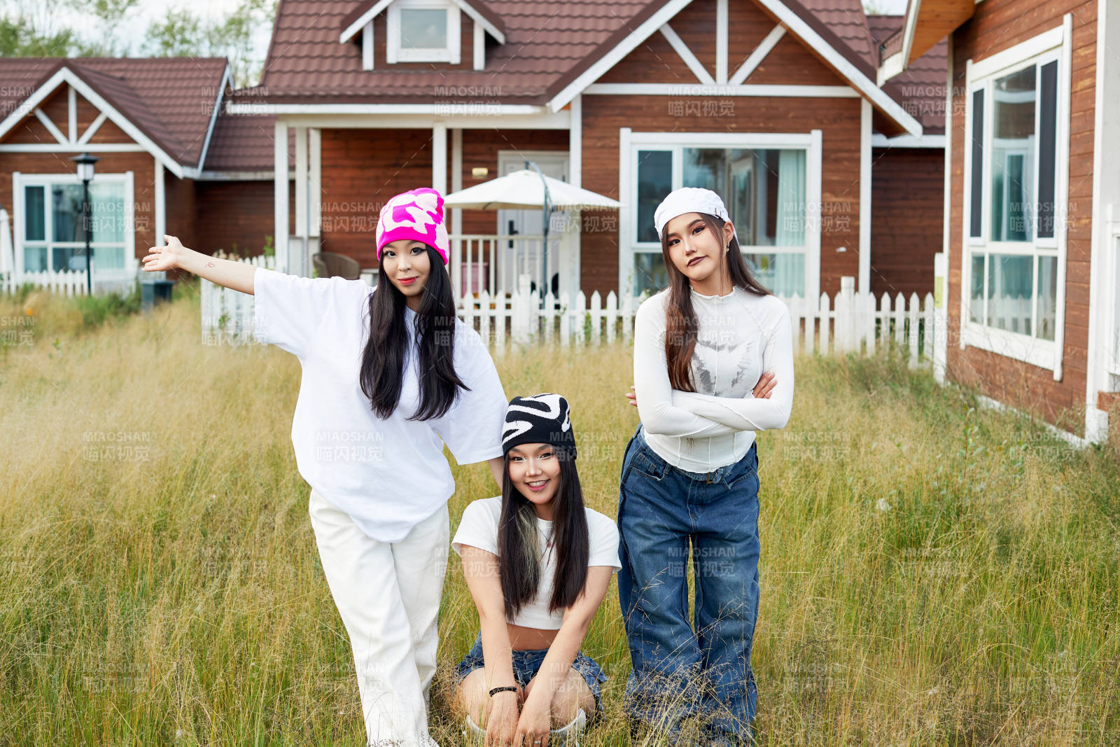 在旅游景区民宿外游玩拍照的三个姑娘们