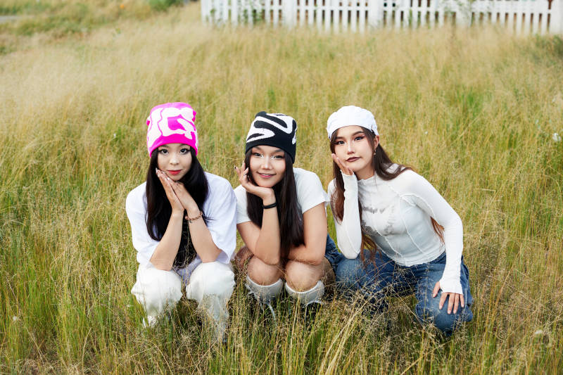 在旅游景区民宿外游玩拍照的三个姑娘们