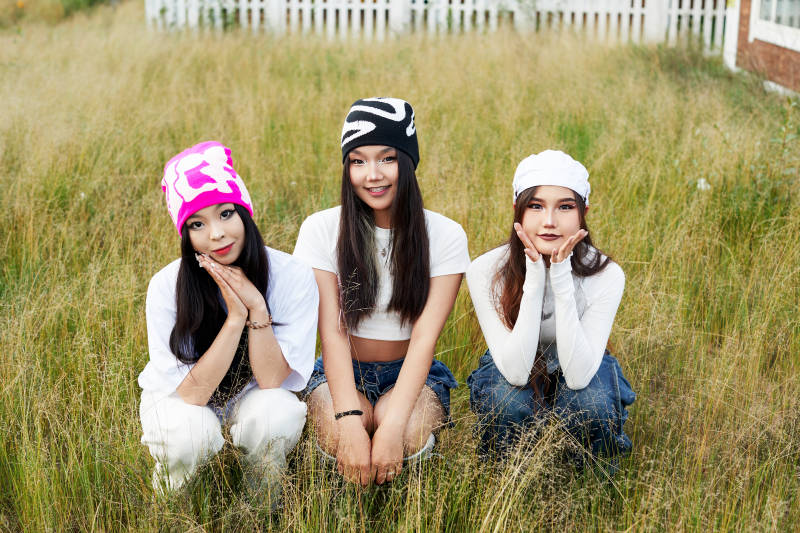 在旅游景区民宿外游玩拍照的三个姑娘们