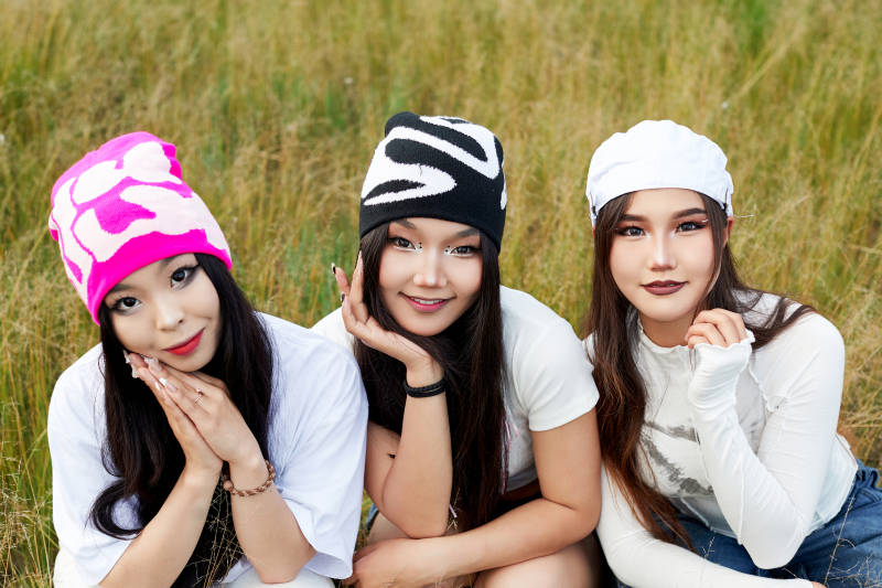 在旅游景区民宿外游玩拍照的三个姑娘们