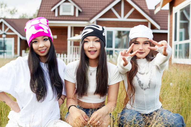 在旅游景区民宿外游玩拍照的三个姑娘们
