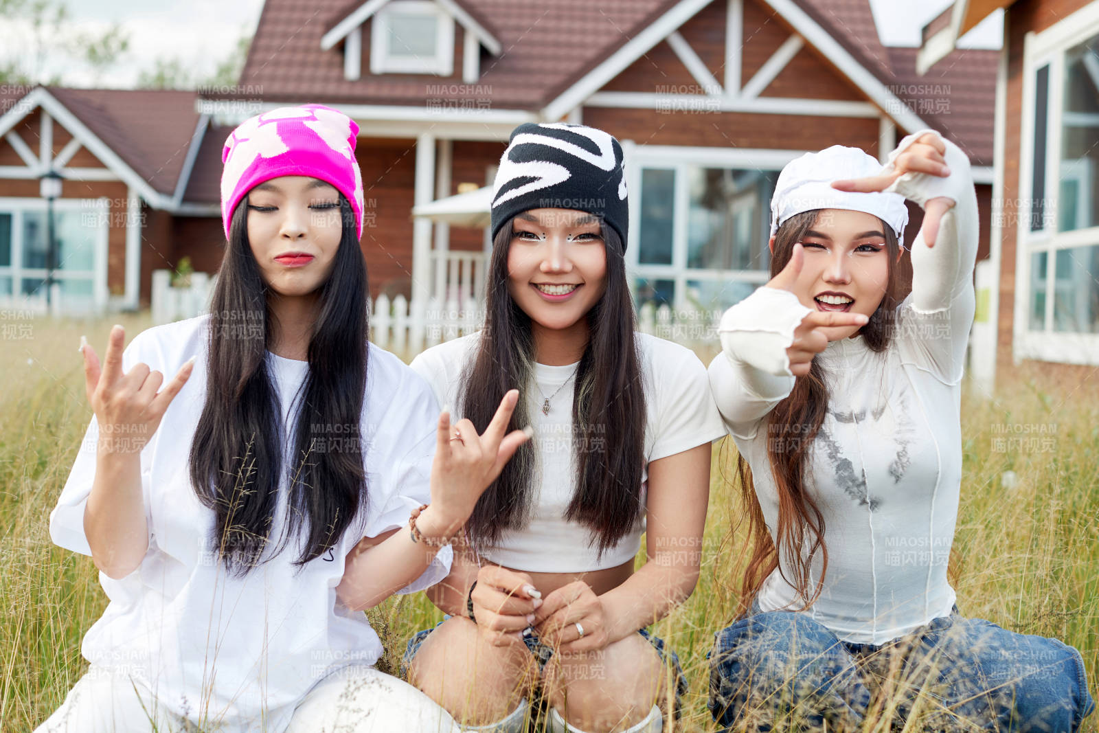 在旅游景区民宿外游玩拍照的三个姑娘们