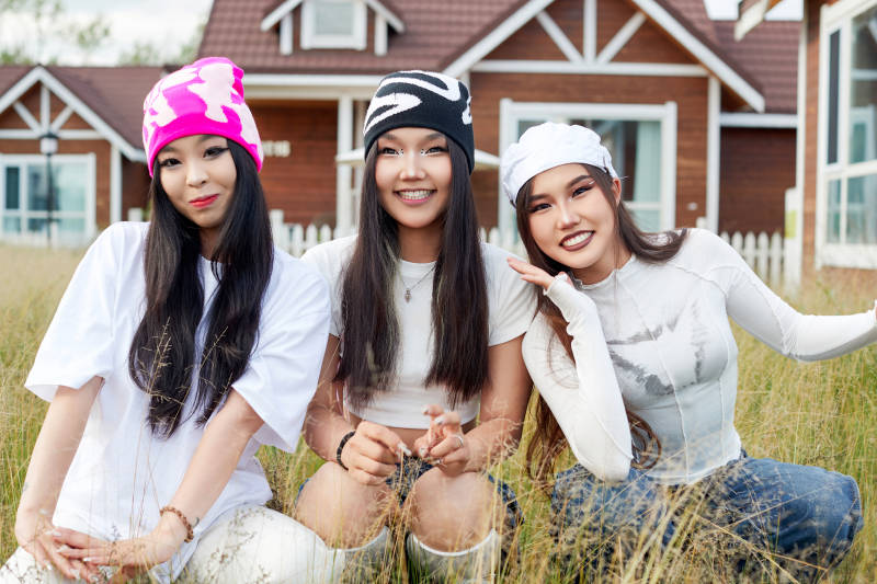 在旅游景区民宿外游玩拍照的三个姑娘们