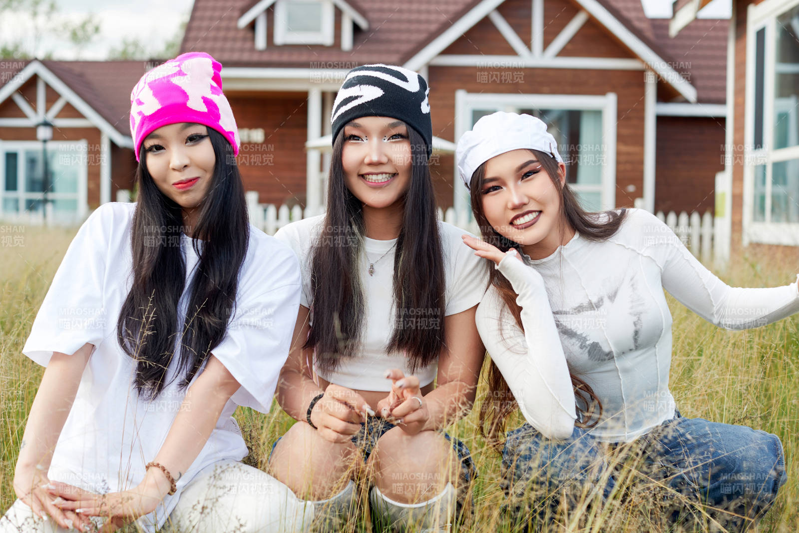 在旅游景区民宿外游玩拍照的三个姑娘们