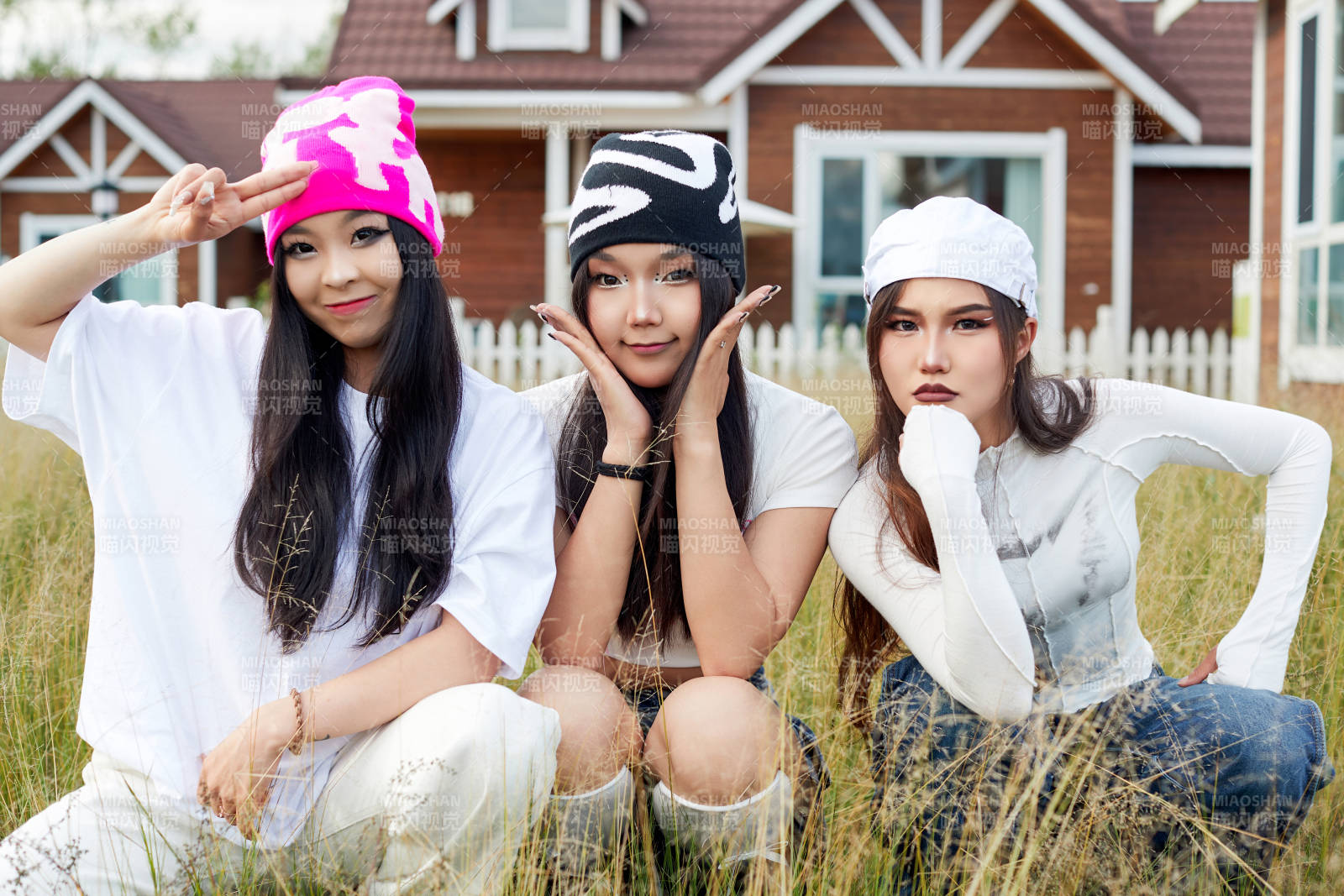 在旅游景区民宿外游玩拍照的三个姑娘们
