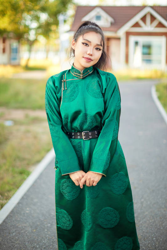 室内穿着绿色蒙古袍的蒙古族年轻女性