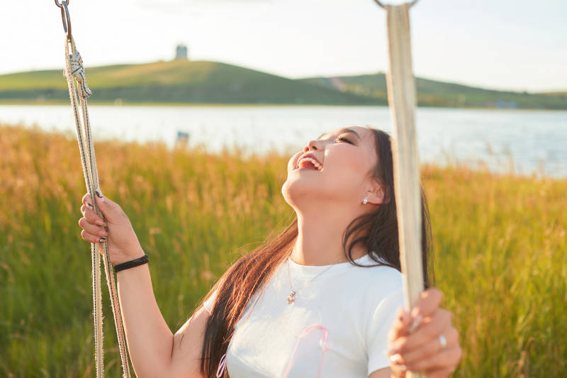 盛夏湖畔荡秋千的亚洲美女
