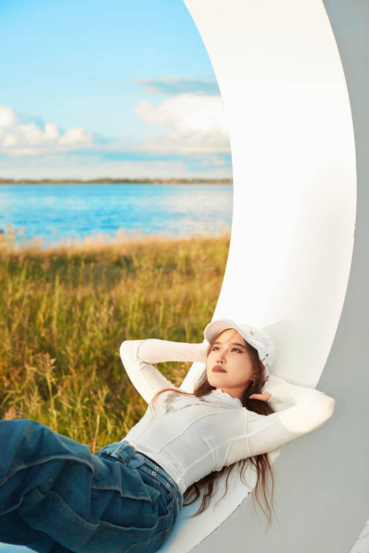 在旅游区湖边打卡点拍照的美女