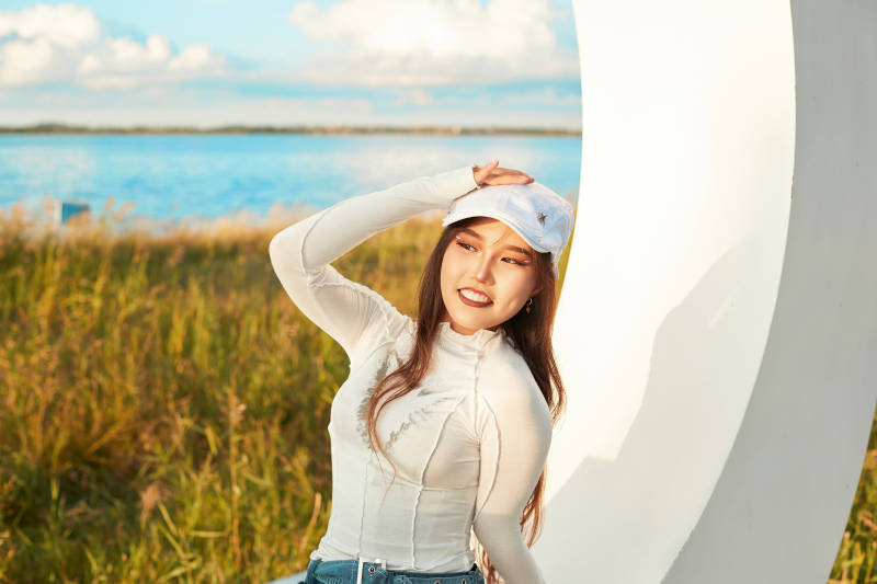 在旅游区湖边打卡点拍照的美女