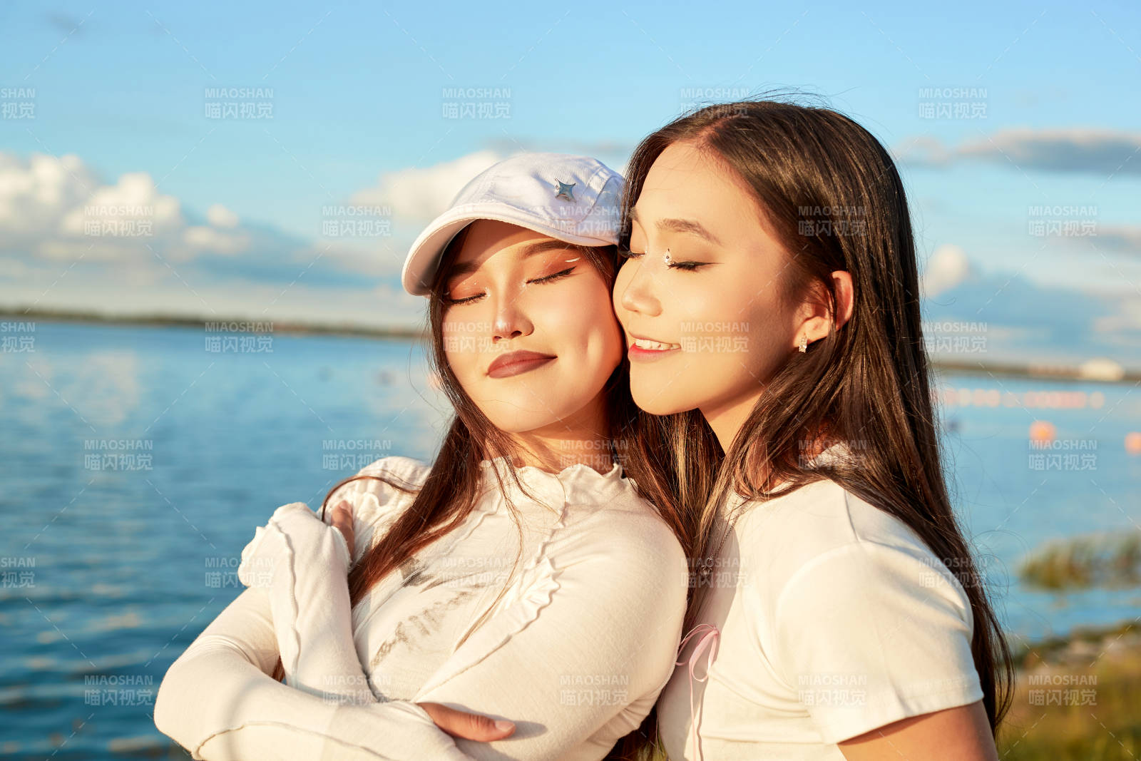 在旅游区湖边打卡点拍照的美女闺蜜