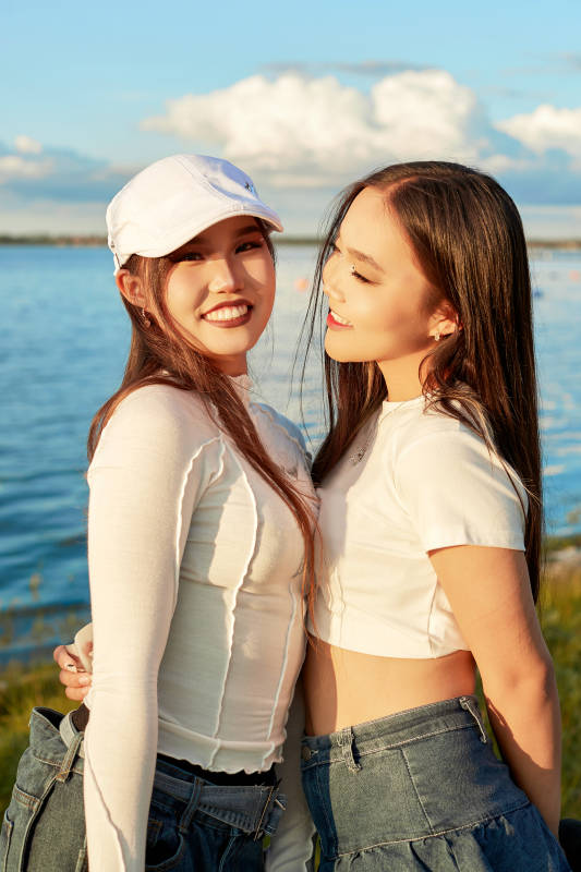 在旅游区湖边打卡点拍照的美女闺蜜