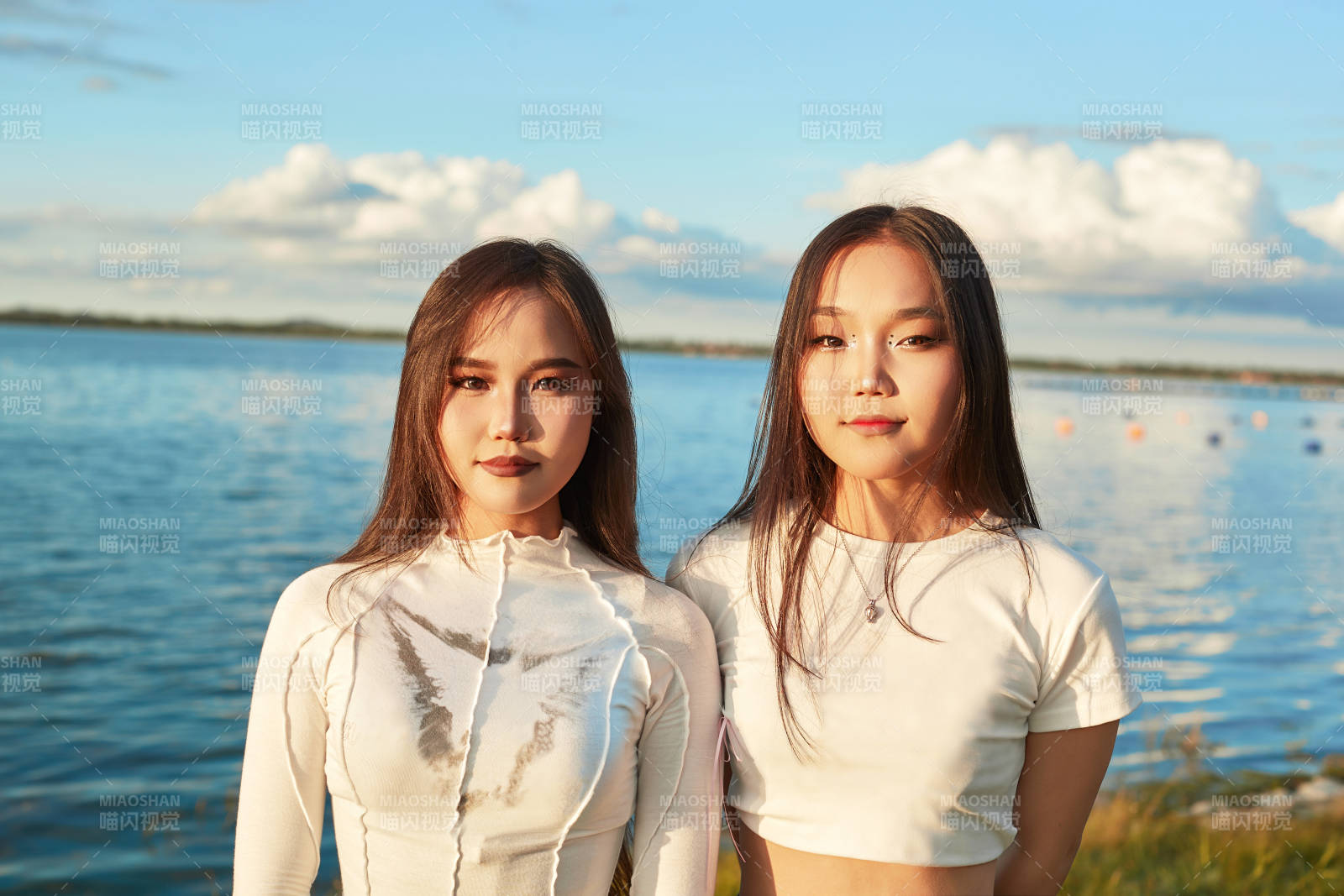 在旅游区湖边打卡点拍照的美女闺蜜