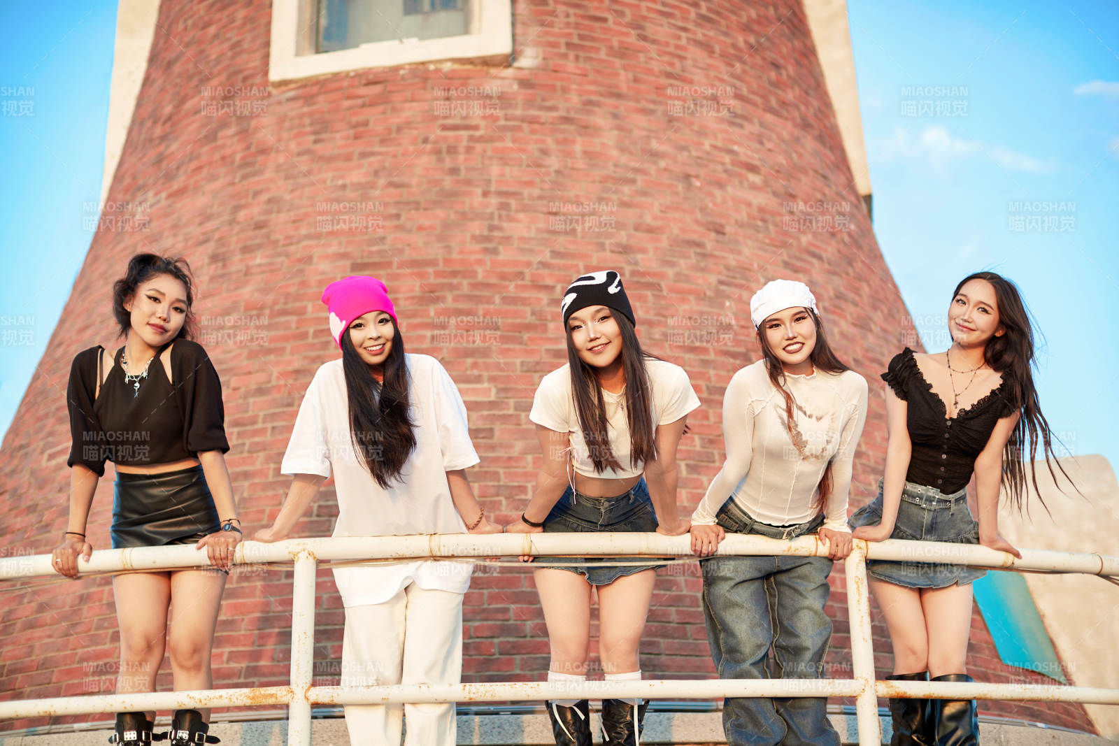 盛夏在草原湖边灯塔上拍照游玩的姑娘们