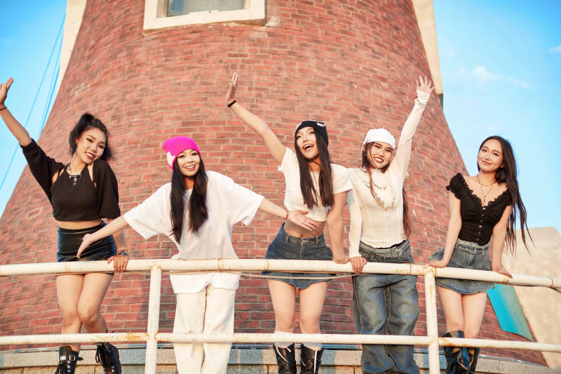 盛夏在草原湖边灯塔上拍照游玩的姑娘们