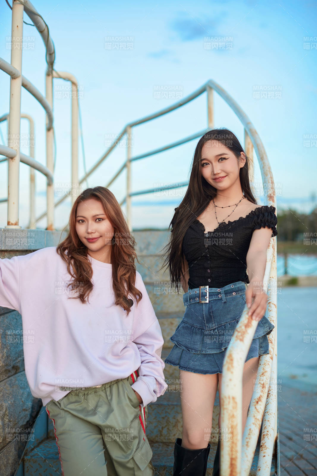 盛夏在草原湖边灯塔上拍照游玩的姑娘们